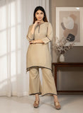 Woman wearing a beige kurta with palazzo pants in a well-lit room.