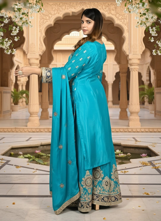 Woman in a turquoise saree with floral decorations in the background