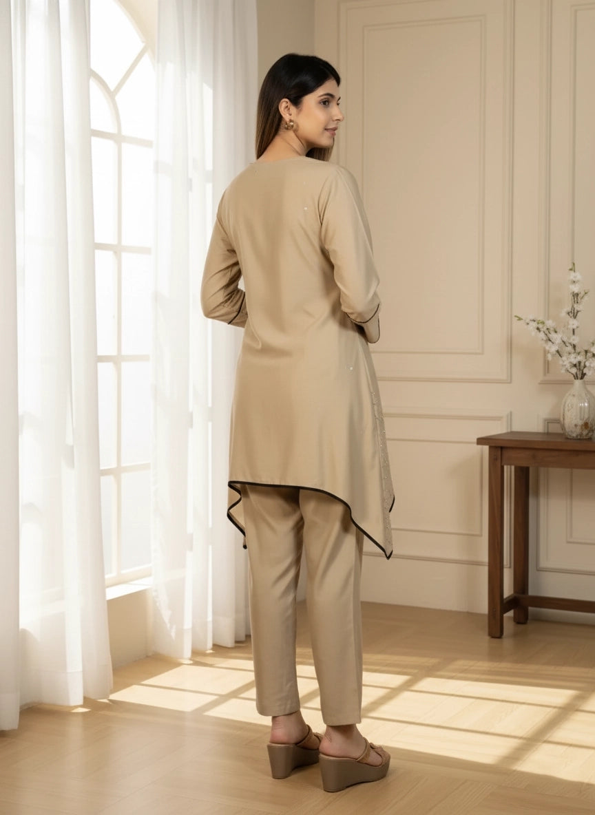 Woman wearing a beige kurta with pants in a well-lit room.