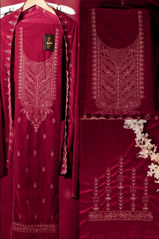 Maroon embroidered traditional outfit with detailed patterns on a red background