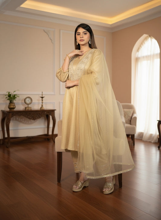 Woman in a light yellow traditional outfit standing in a well-lit room with wooden flooring and decorative elements.