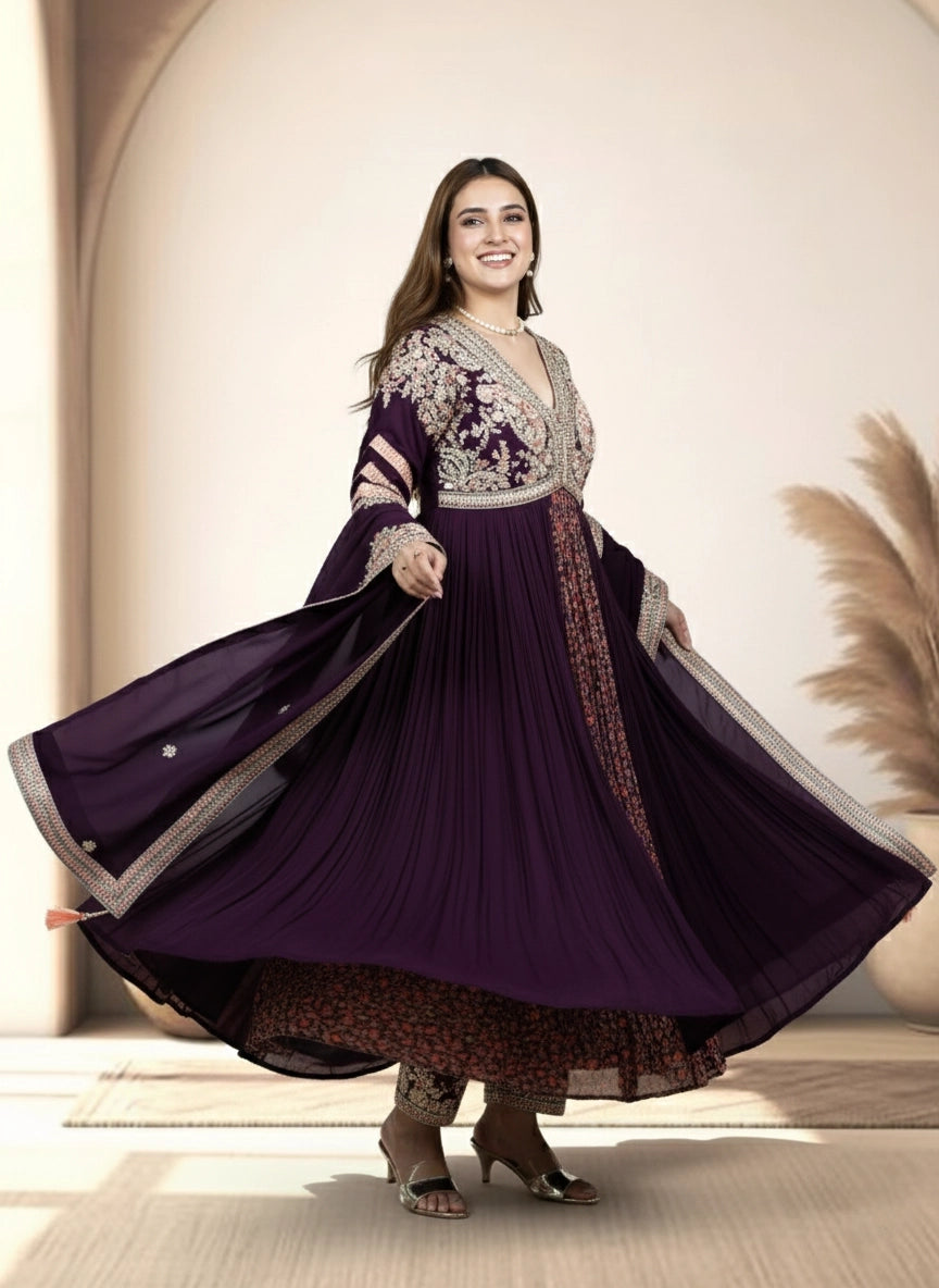 Woman wearing a long purple dress with floral patterns in an indoor setting