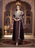 Woman in a traditional outfit standing in an ornate room with decorative walls and furniture.