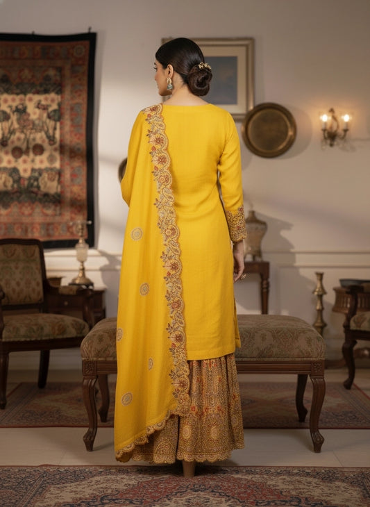Woman in a yellow traditional outfit with floral patterns in a decorated room.