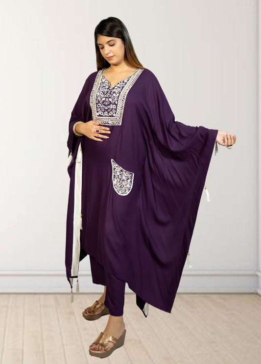 Woman wearing a purple outfit with white embroidery against a plain background