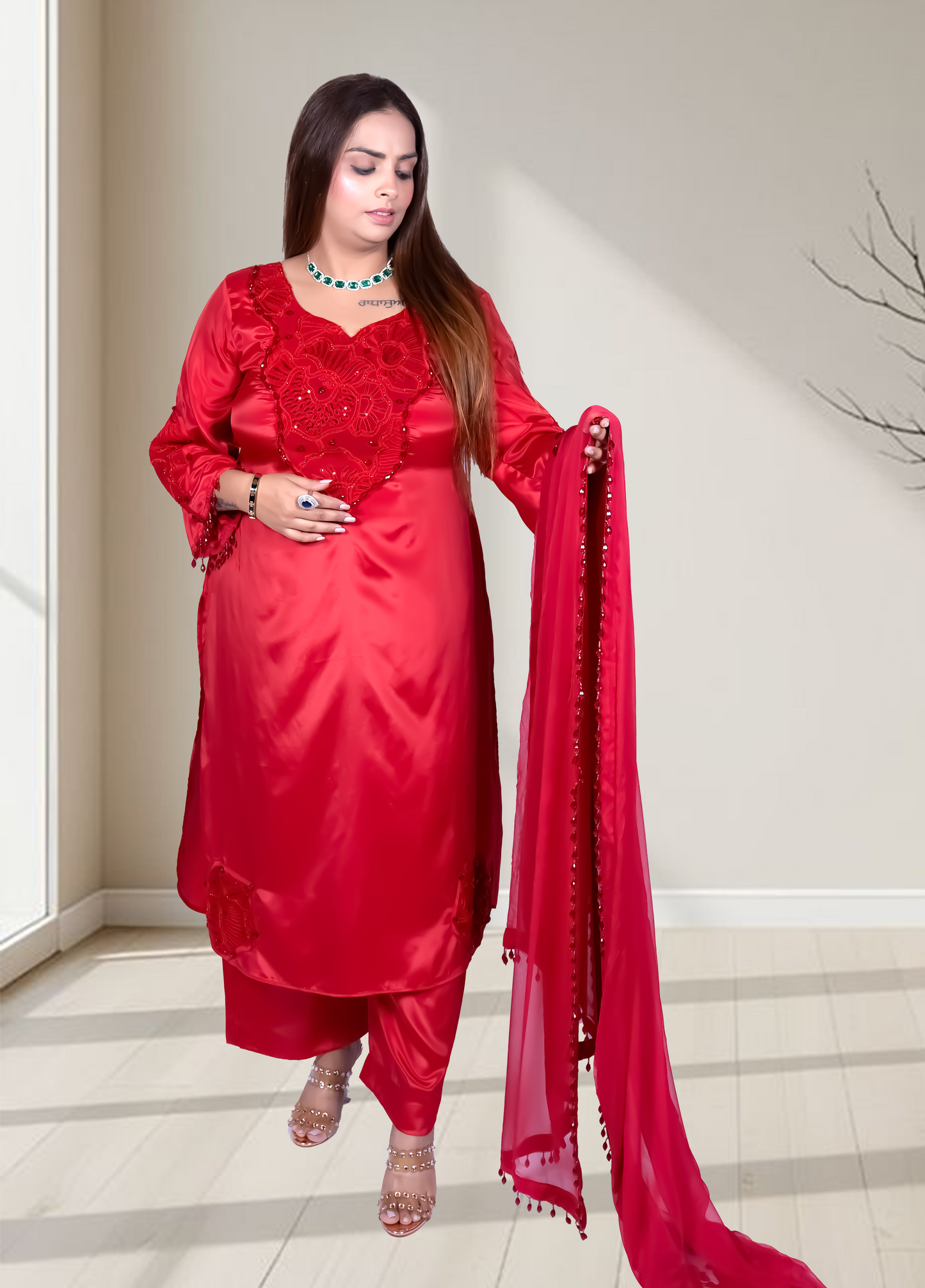 Woman in a red traditional outfit with a matching dupatta indoors.