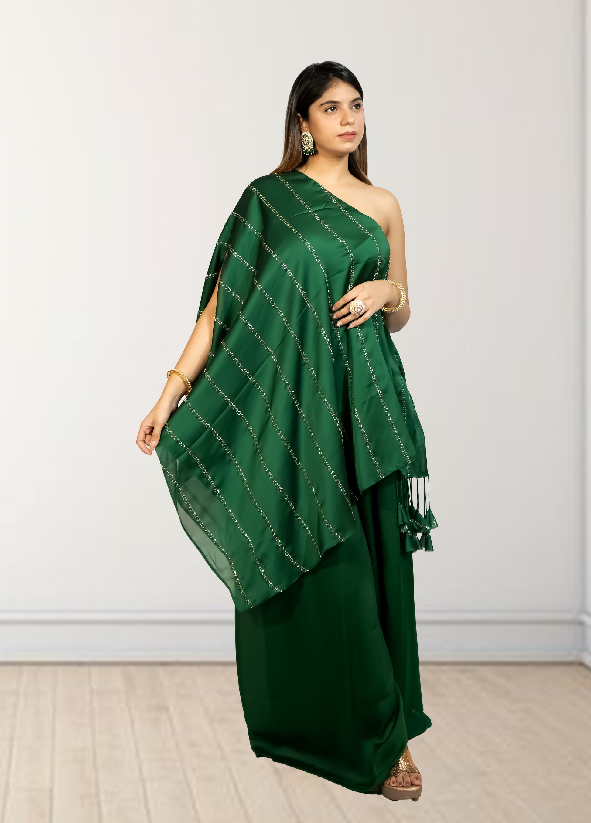 Woman wearing a green saree with a white wall background