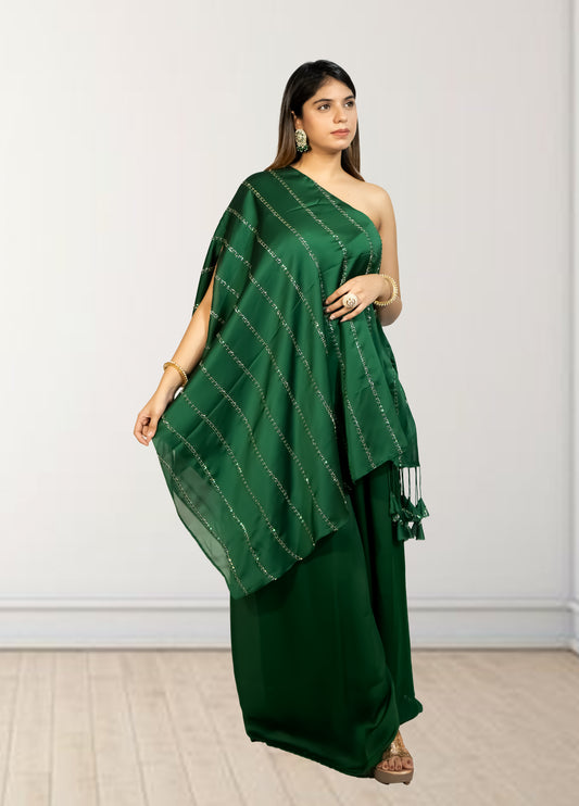 Woman wearing a green saree with a white wall background