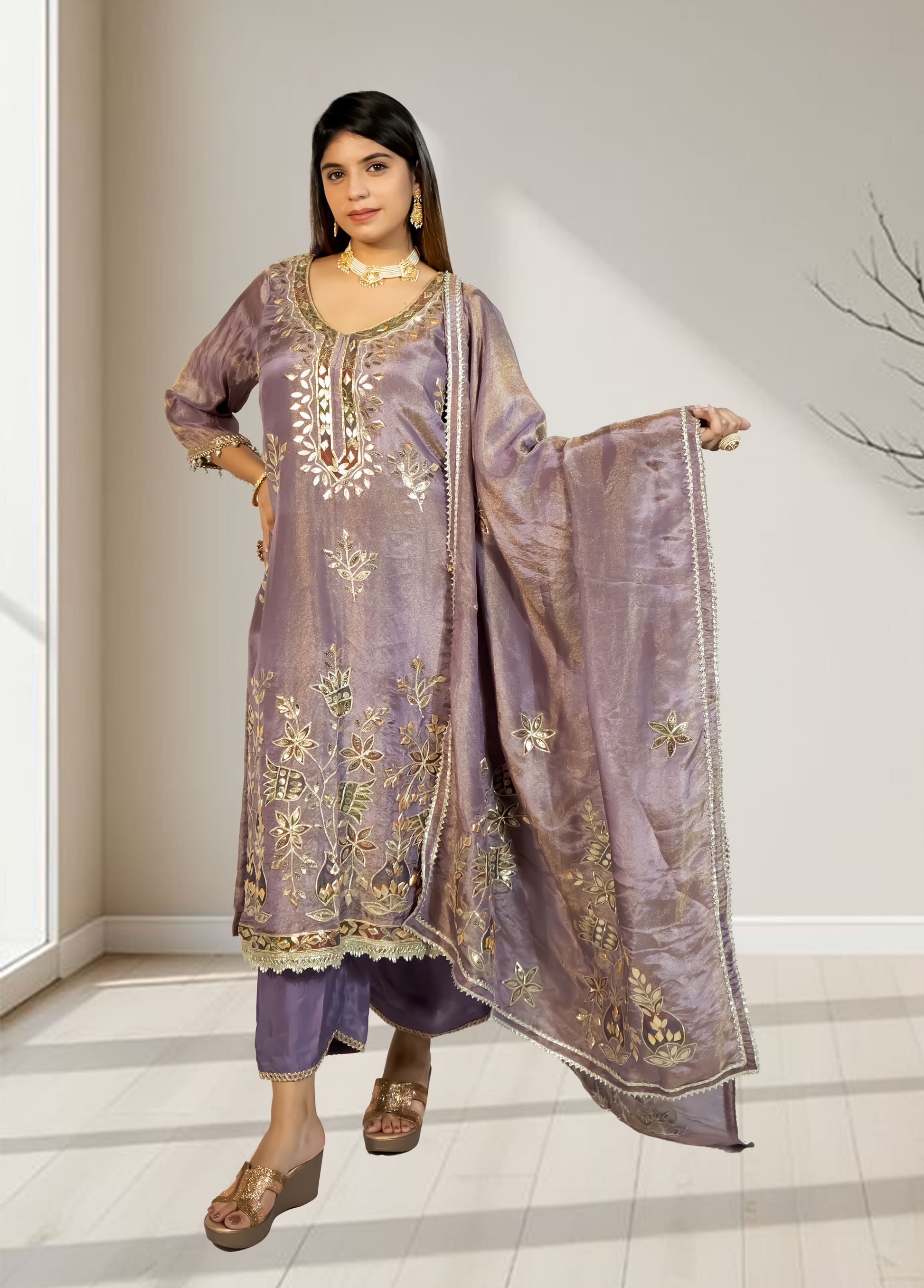 Woman wearing a traditional embroidered outfit in a well-lit room.
