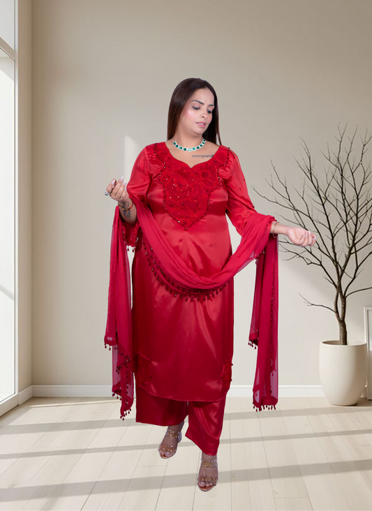 Woman in a red traditional outfit standing in a room with a neutral color scheme.