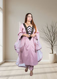 Woman in a pink traditional outfit standing in a well-lit room with a plant in the background.