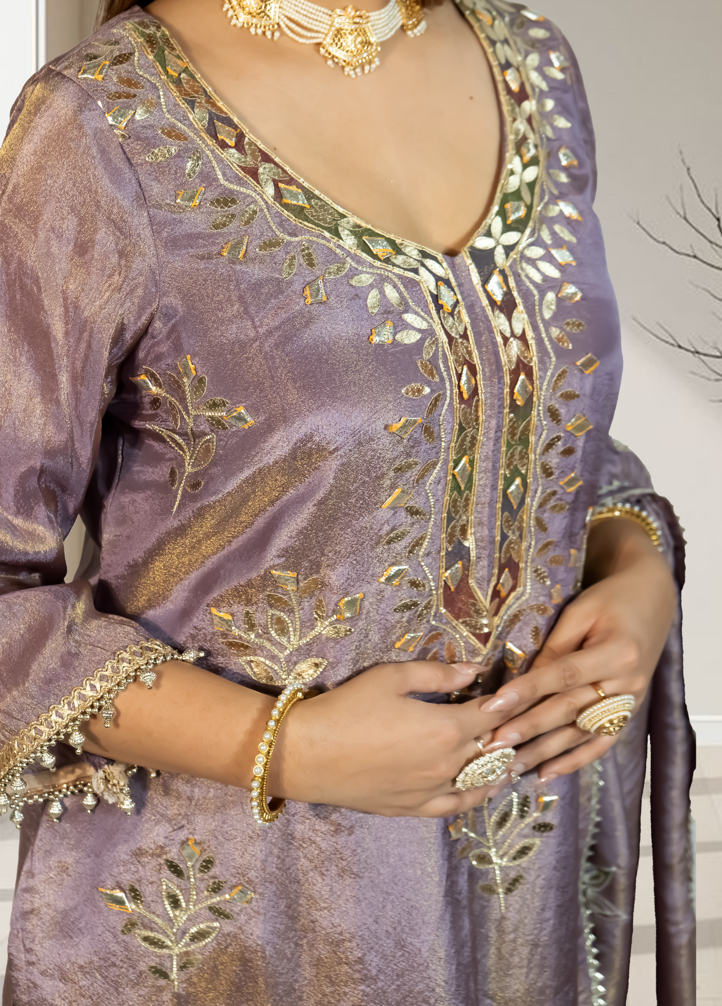 Purple embroidered garment with gold detailing worn by a person.