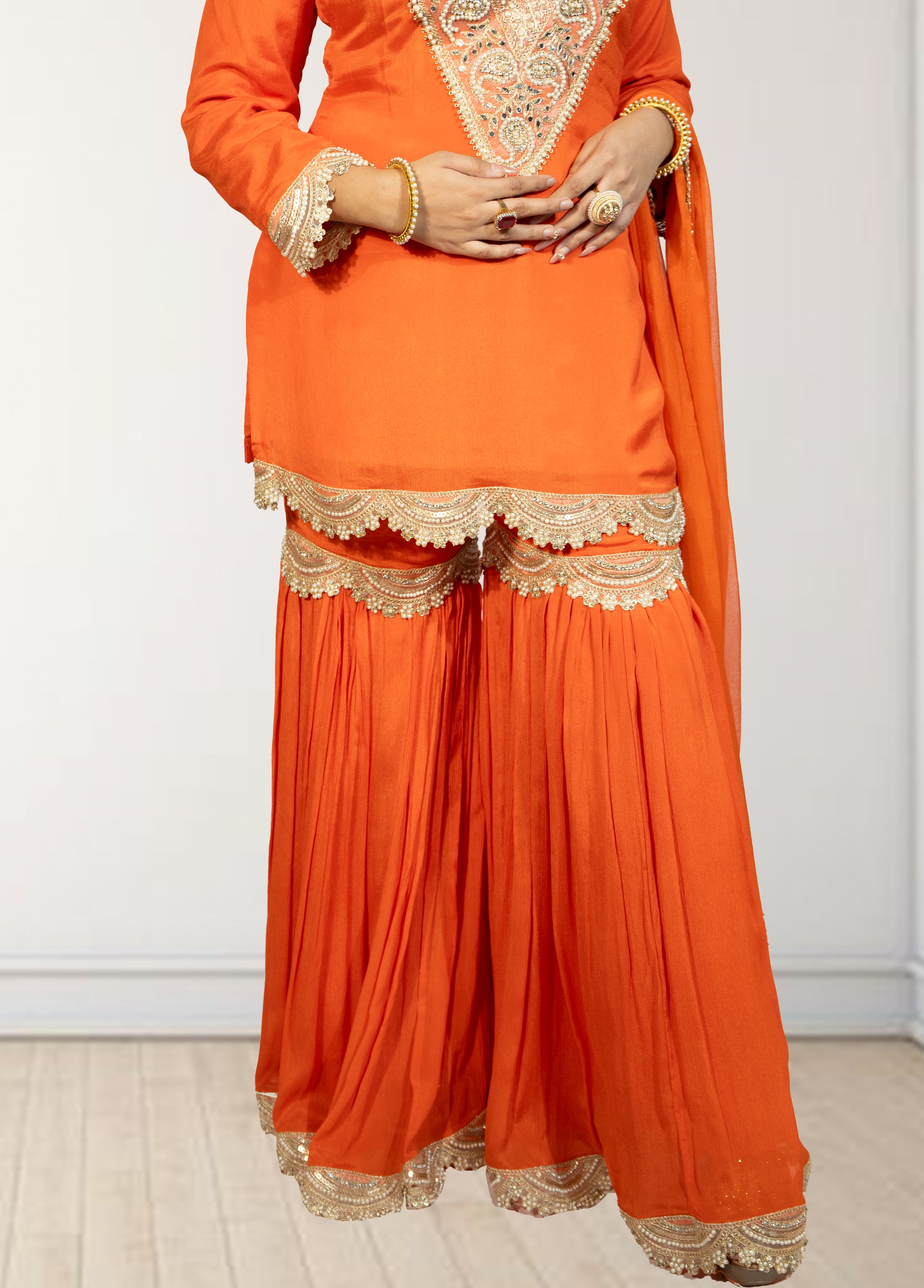 Orange traditional outfit with gold embroidery on a white background
