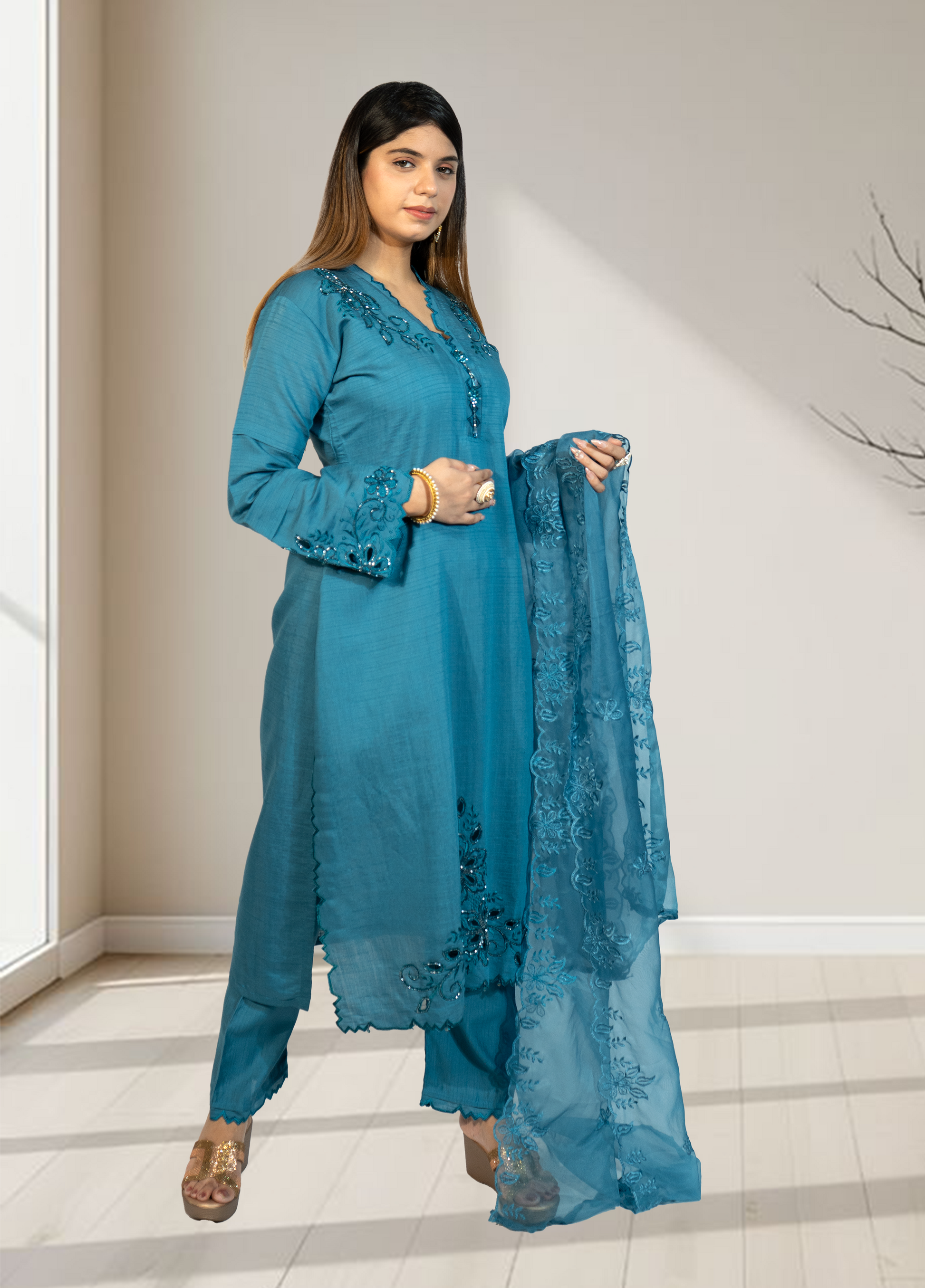 Woman wearing a blue traditional outfit with a matching dupatta indoors.