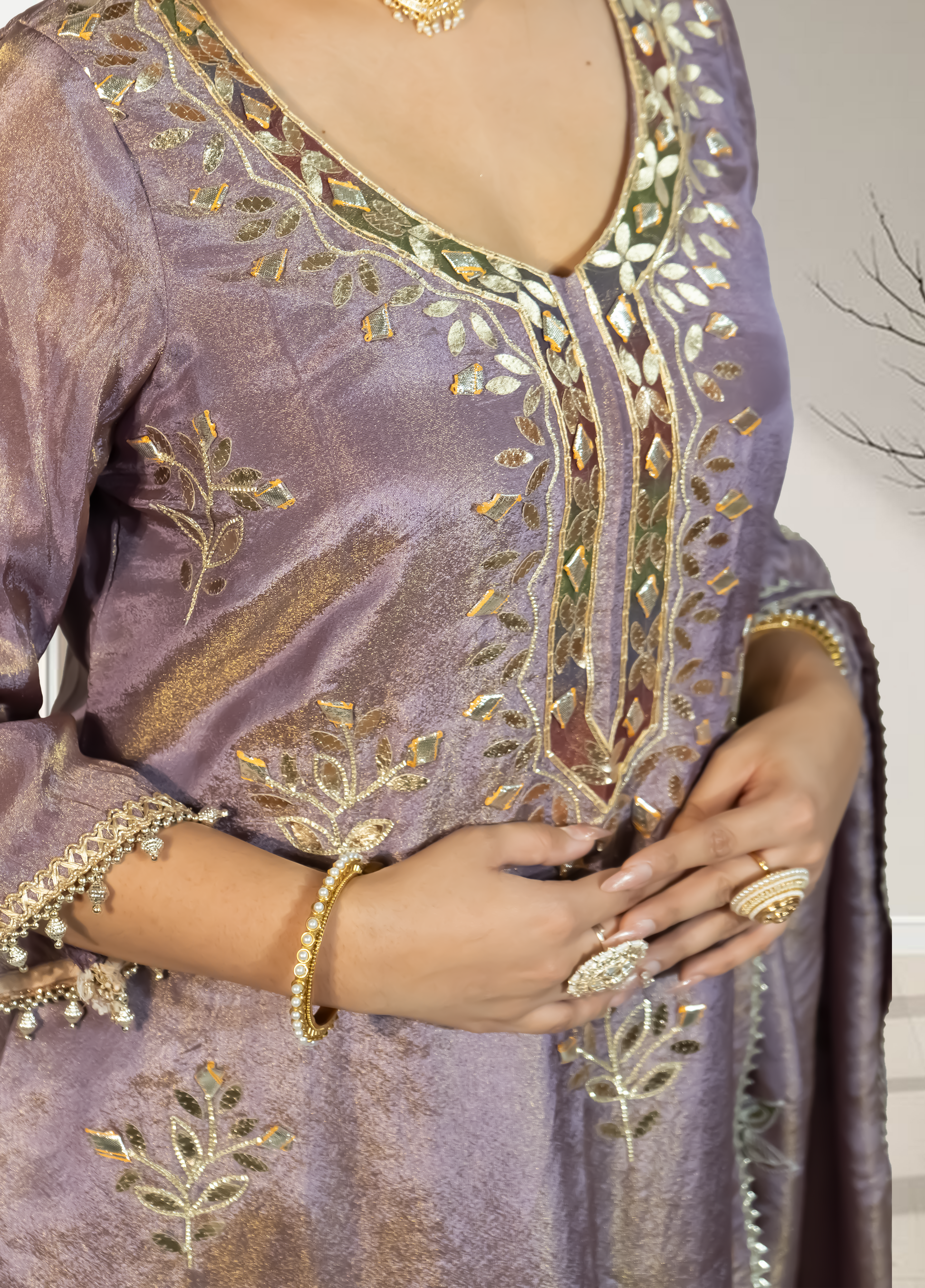 Purple embroidered garment with gold detailing worn by a person.