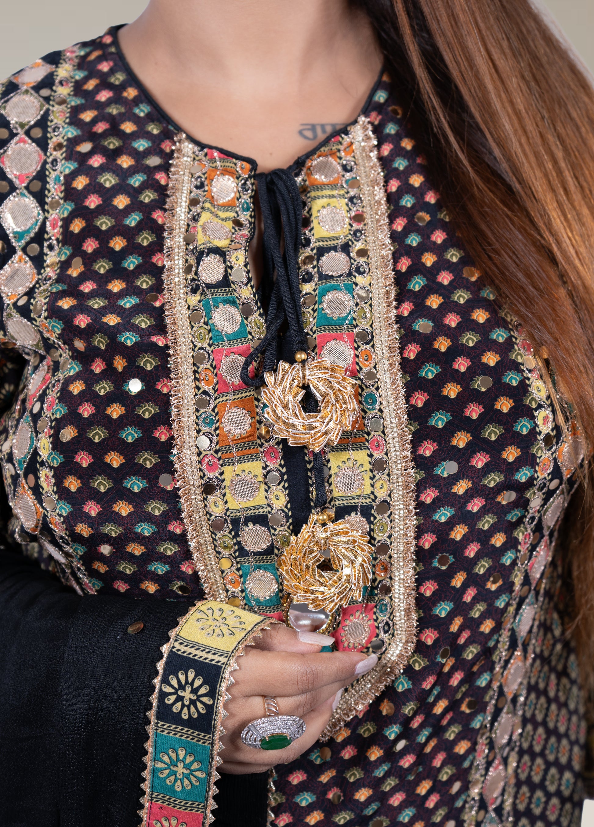 Person wearing a intricately designed garment with colorful patterns and embroidery.