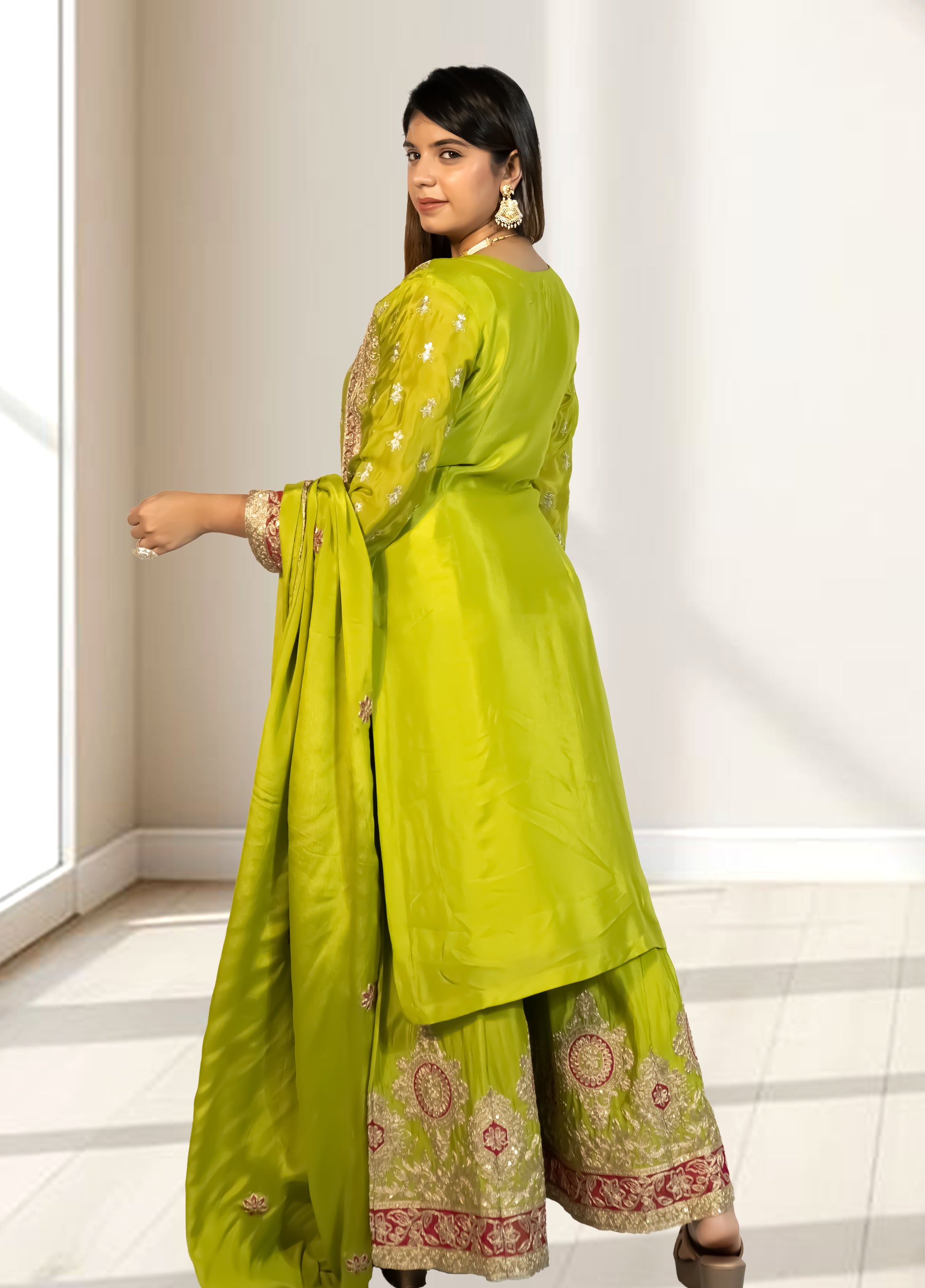 Woman wearing a green traditional outfit with a white background