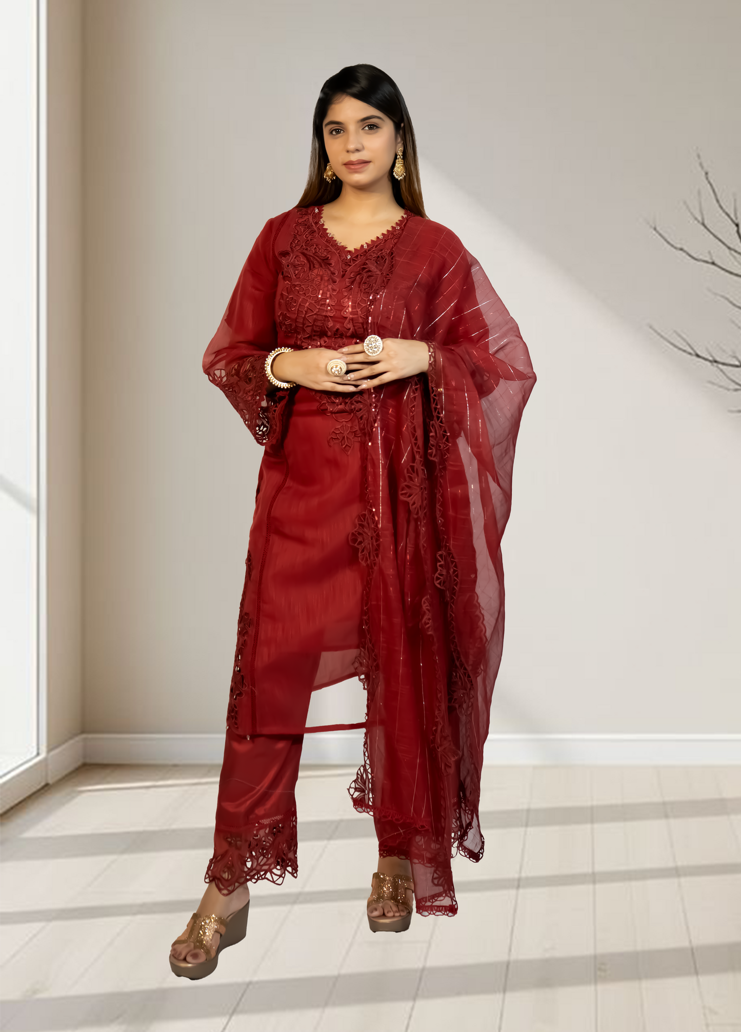 Woman wearing a red lace outfit standing indoors with a neutral background
