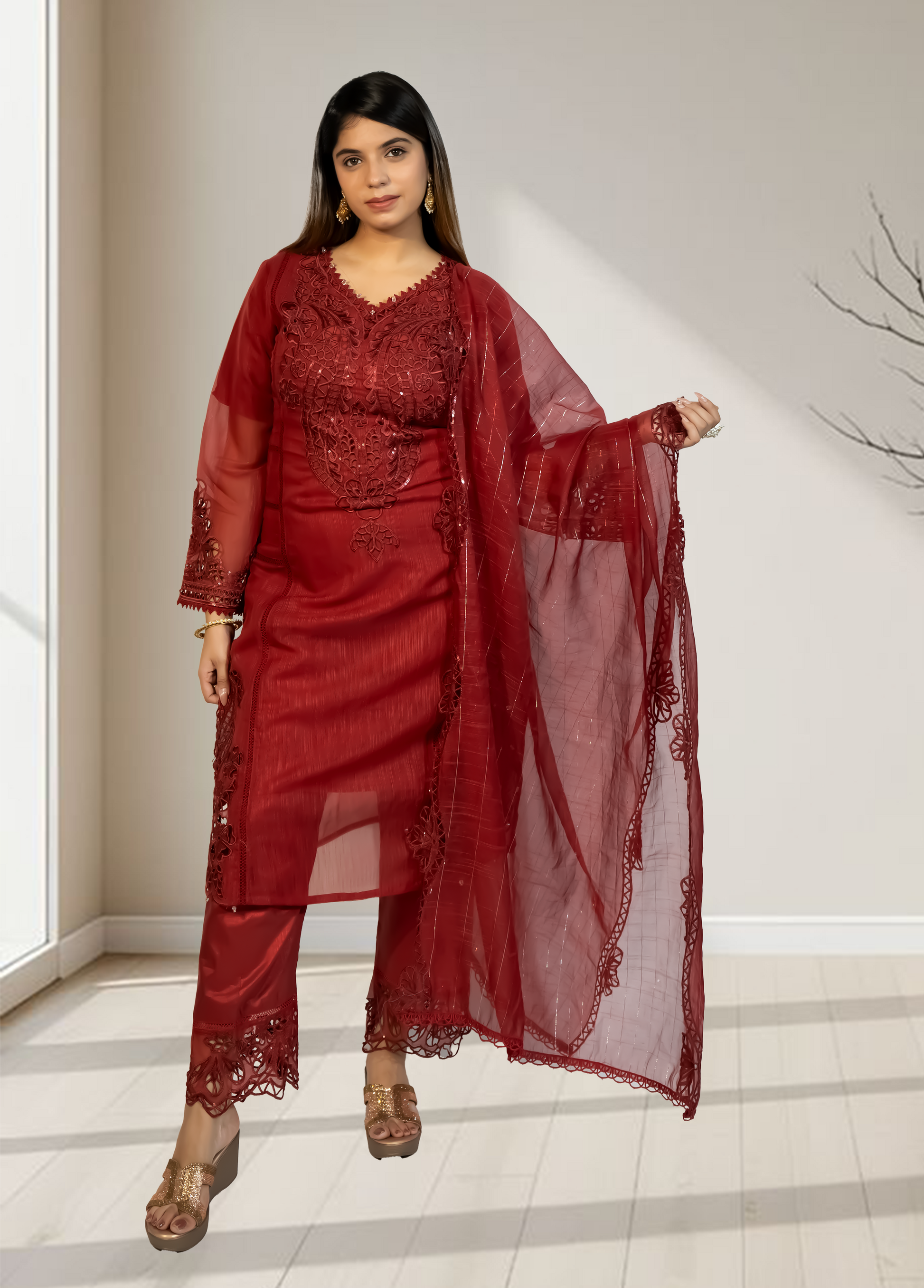 Woman wearing a red traditional outfit with a sheer dupatta in a minimal indoor setting