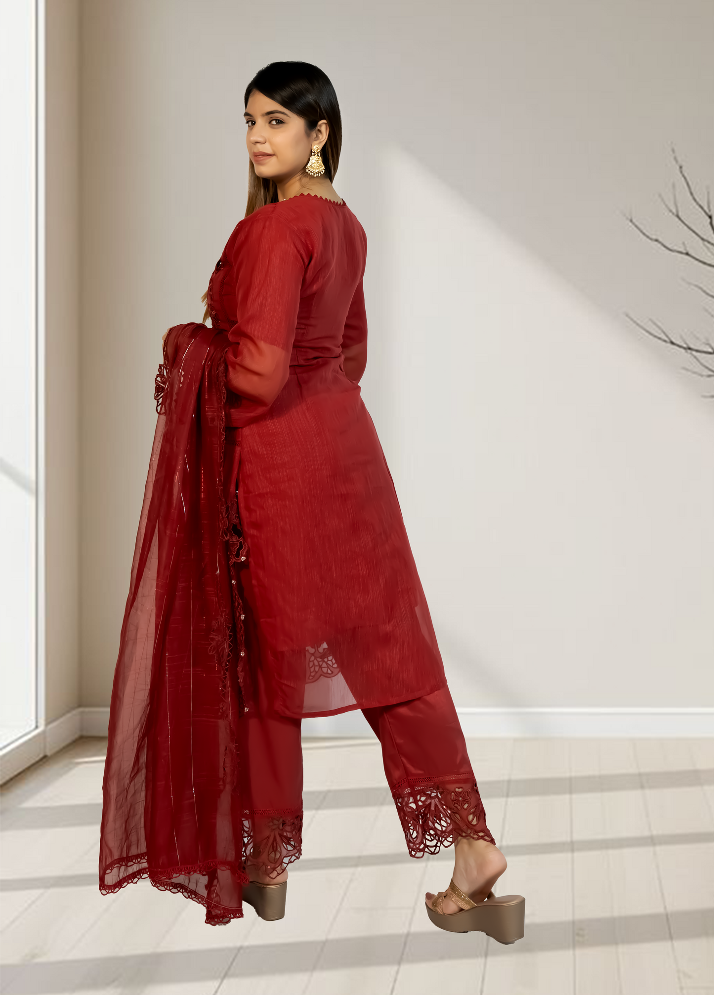 Woman wearing a red outfit with lace details in a minimal indoor setting