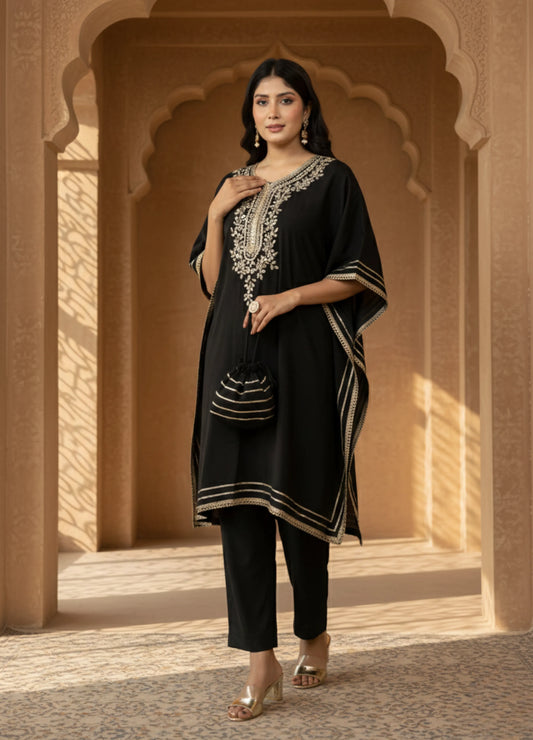 Woman wearing a black traditional outfit with intricate white embroidery in an architectural setting.