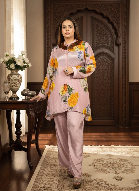 Woman in a floral top and pink pants standing in an ornate room.