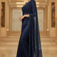 Woman wearing a navy blue saree with a matching blouse in an indoor setting.