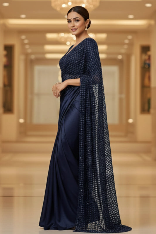 Woman wearing a navy blue saree with a matching blouse in an indoor setting.