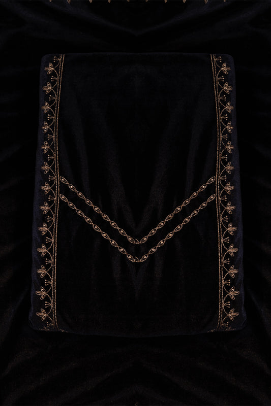 Black velvet fabric with gold embroidery on a dark background
