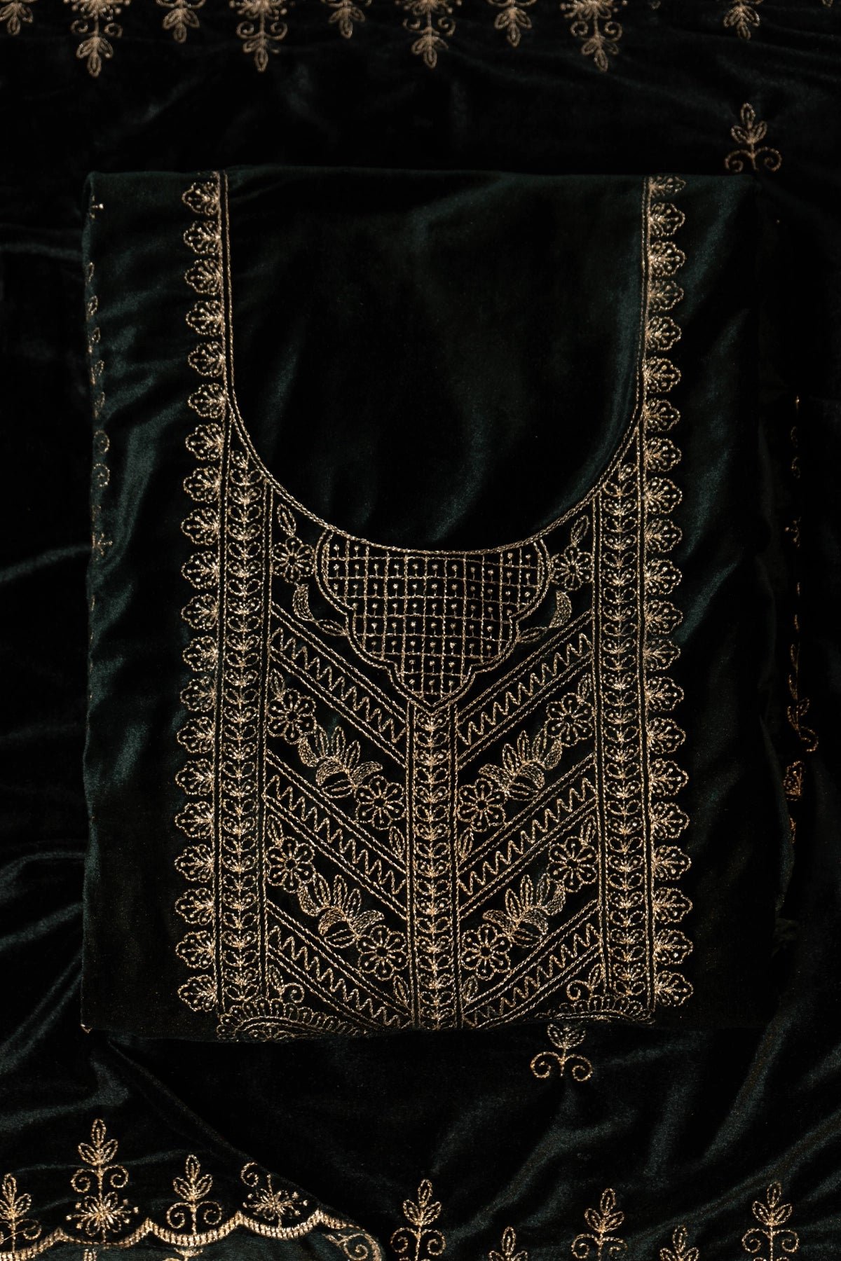 Black velvet garment with gold embroidery on a black background
