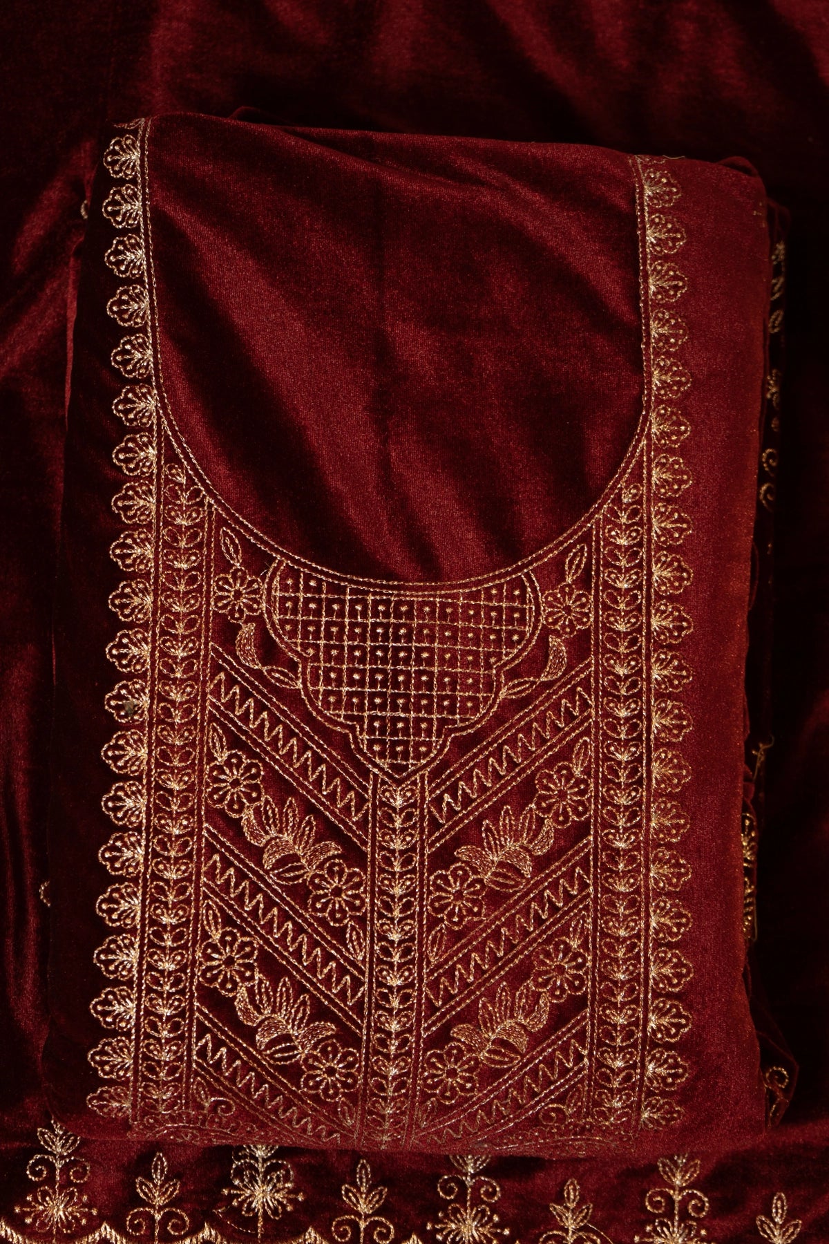Maroon fabric with intricate gold embroidery
