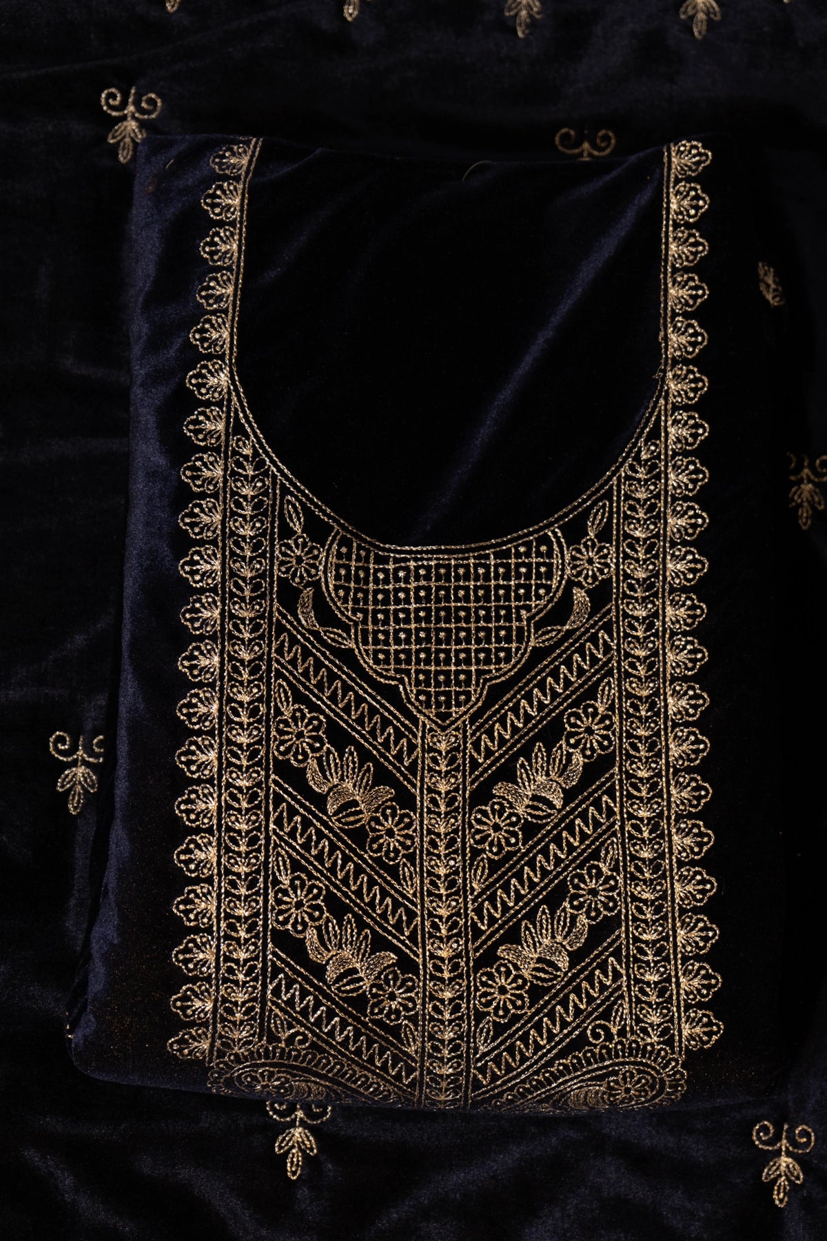 Black fabric with gold embroidery on a dark background