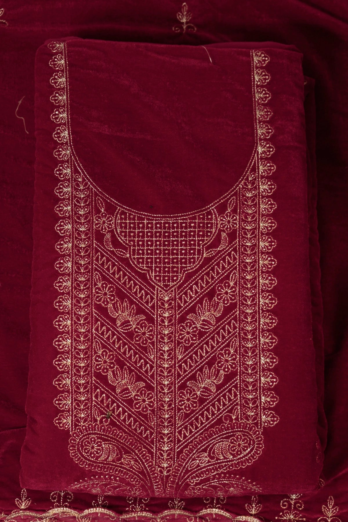 Maroon fabric with intricate gold embroidery on a matching background