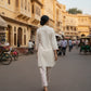 Woman walking on a street in an urban area with yellow buildings.