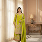 Woman in a green traditional outfit standing in a well-lit room with decorative elements.