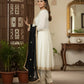 Woman in a white traditional outfit with a black dupatta in an ornate room.