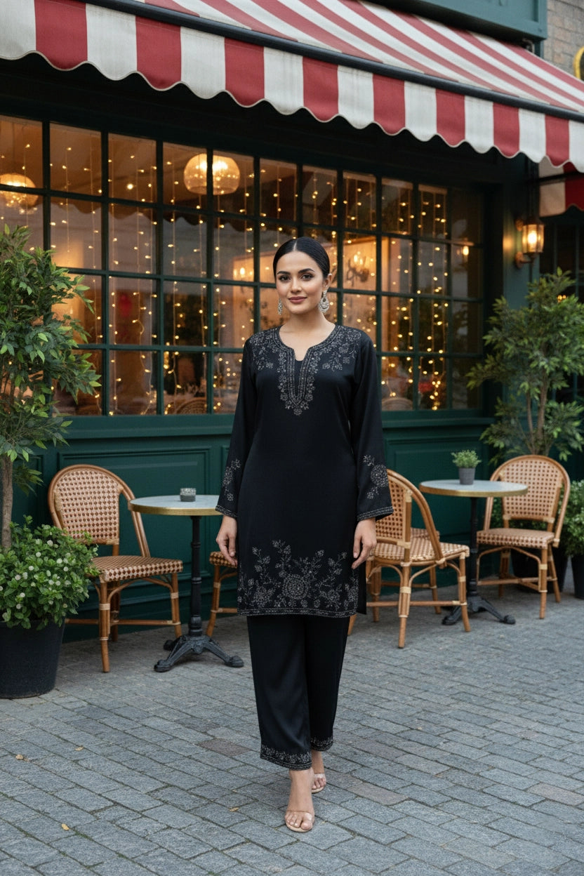Woman in a black outfit standing in front of a restaurant with a striped awning.