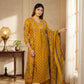 Woman in a yellow traditional outfit standing in a well-lit room.