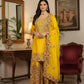Woman in a yellow and gold traditional outfit standing in an elegant room with a mirror and chair.