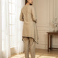 Woman wearing a beige kurta with pants in a well-lit room.