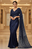 Woman wearing a navy blue saree with a matching blouse in an indoor setting.