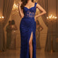 Woman in a blue evening gown with a high slit in a glamorous setting.