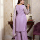 Woman in a lavender traditional outfit standing in a room with a mirror and decor.