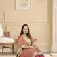 Woman in traditional attire sitting in a room with beige walls and a chair.