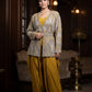 Woman in a traditional outfit standing in an elegant room with dim lighting.