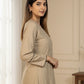 Woman wearing a beige dress with black trim indoors