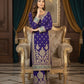 Woman in a purple embroidered outfit sitting on an ornate chair in a decorated room.