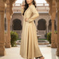 Woman in a beige traditional outfit standing in an ornate architectural setting