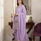 Woman in a lavender traditional outfit standing in front of a mirror.