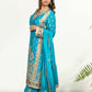 Woman wearing a blue embroidered saree with a white background